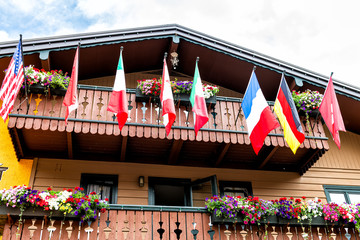 Vail Swiss style resort town in Colorado with low angle view of many flags on Gore Creek drive exterior of house balcony