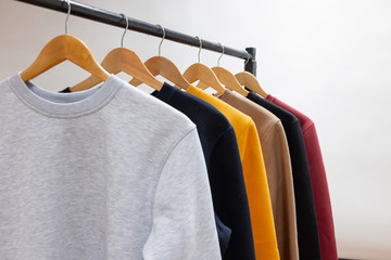Blank sweatshirts hanging on a hanger in the wardrobe or showroom