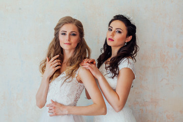 two girls in white dresses brunette and blonde