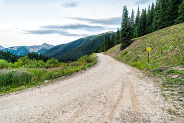 Fototapeta na wymiar Wide angle view of green alpine mountains with dirt road leading to Ophir pass near Columbine lake trail in Silverton, Colorado in 2019 summer morning