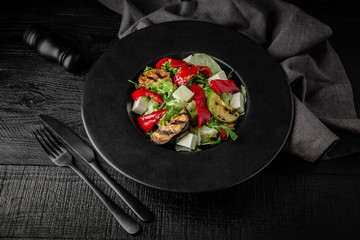 Grilled vegetable salad: zucchini, eggplant, bell peppers, herbs and feta cheese. Nutritious, dietary, fitness food. Black boards background