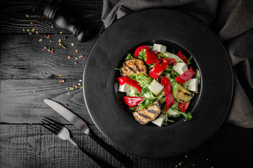 Grilled vegetable salad: zucchini, eggplant, bell peppers, herbs and feta cheese. Nutritious, dietary, fitness food. Black boards background