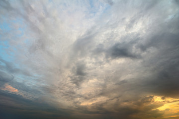 Fototapeta premium Sunset sky covered with orange puffy clouds in the evening.