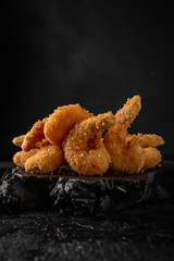 Deep fried royal prawn on black background. Snack to beer. Fast food.