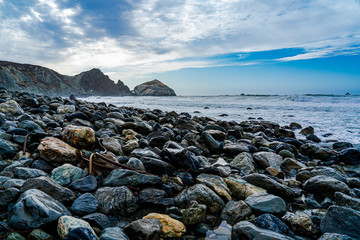 Fototapeta na wymiar Black rocks on the beach in California