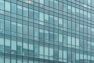 Obraz na płótnie Canvas Glass facade texture of a modern office building. High tech architecture. Elements of urban design. Windows of skyscraper tower.