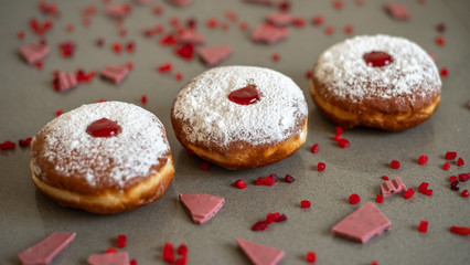 Hanukkah background with fresh donuts an pink ruby chocolate.