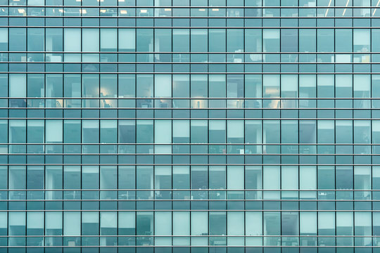 Glass facade texture of a modern office building. High tech architecture. Elements of urban design. Windows of skyscraper tower.
