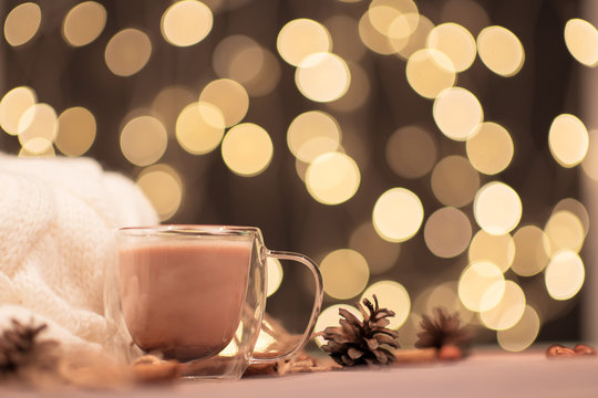 Cup of warm cocoa on the dark gold bokeh background, sweaters. Christmas drink, winter holiday mood