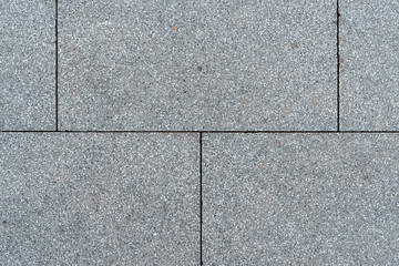 Texture of gray horizontal road granite tiles. Stone background. Modern paving slabs. Motley...