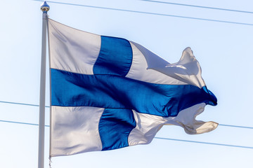 Finnish flag in front of blue sky.