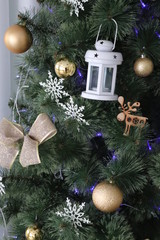 christmas tree with decorations, gold balls, blue lights, wooden deer
