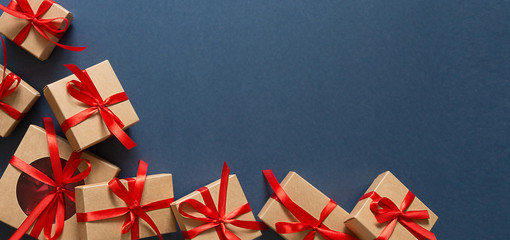 Christmas flat lay. Holiday gifts in boxes in craft paper and a red ribbon on a classic blue background 2020.Zero waste, Christmas eco-friendly gift wrapping gift wrapping concept, eco friendly banner