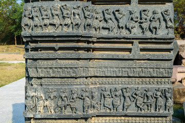 Beautiful carvings of dancing figurines on the dilapidated wall in the ruins of the ancient Warangal Fort in Warangal, India.