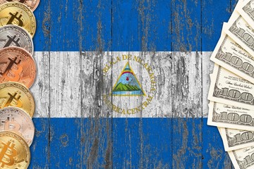 Nicaragua savings concept. Bitcoins and dollar banknotes on the side of national flag with wooden background. Trading currencies.