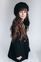 Close up portrait of little cute adorable girl posing alone on isolated white background in studio. Childhood, fashion kids, baby model concept