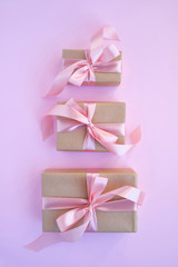 Beautiful present on pink background. Gift kraft package with ribbon and pink bow. Surprise for Christmas, Valentines Day or Mothers Day. Happy holiday mockup. Celebration event. Gift box close-up