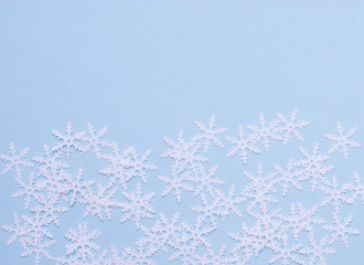 composition of white snowflakes on blue background, flatlay