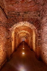 Brick archway made of red bricks as a passage between the two wings of a medieval castle. Granite...