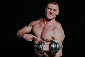 Fototapeta na wymiar Sport the athlete bodybuilder build muscles dumbbells