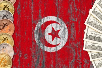 Tunisia savings concept. Bitcoins and dollar banknotes on the side of national flag with wooden background. Trading currencies.