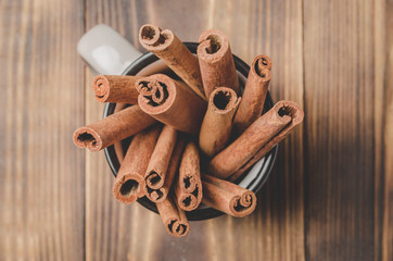 Cinnamon sticks. Top view. Seasoning. Cinnamon sticks in a mug on a wooden table.