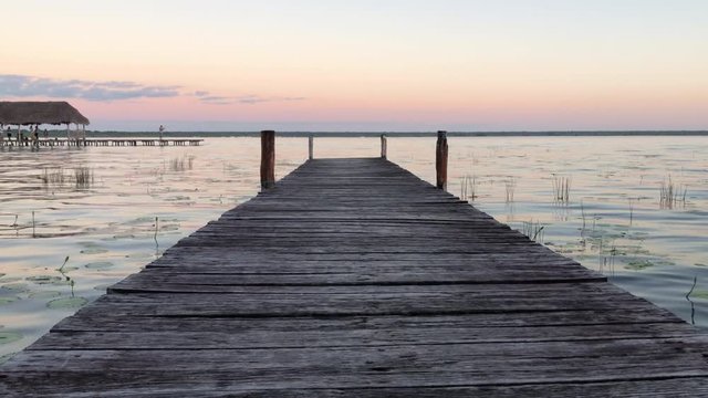 Still View Over the Dock in Lake Bacalar wih Stunning Pink and Yellow Sunset