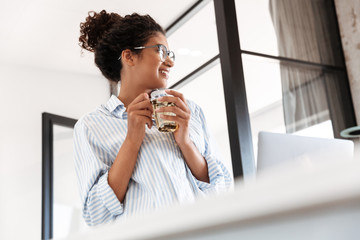 Attractive young african woman working on laptop computer