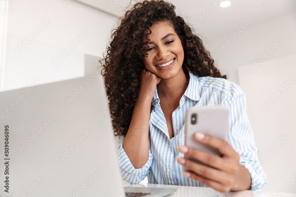 Poster Attractive young african woman working on laptop computer