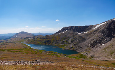 Fototapeta na wymiar Looking down on a sparkling high altitude lake and the mountains beyond from the Beartooth Highway.