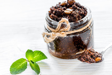Body scrub of ground coffee on white table background