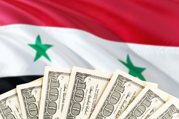 Syria economy concept. Dollar banknotes on the side of national flag with waving background....