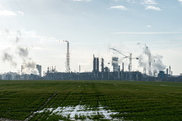Fototapeta na wymiar Chemical industry. Environmental pollution by harmful emissions into the atmosphere. Poisonous smoke comes from the big pipes. The factory poisons nature. Silhouette of pipes and smoke. Sunny day.