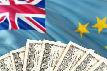 Tuvalu economy concept. Dollar banknotes on the side of national flag with waving background....