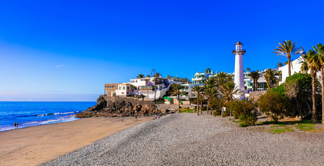 Beautiful beach with lighthouse Playa del Aguila, Bahia Feliz, Grand Canary island - obrazy, fototapety, plakaty