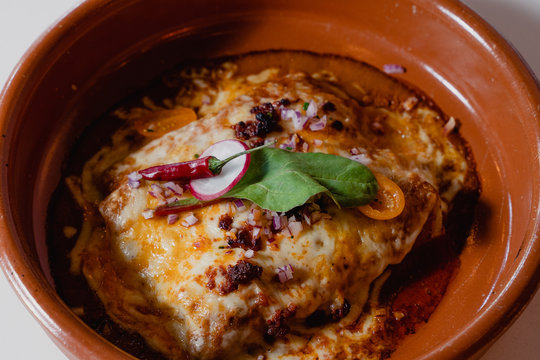 plato de lasa&ntilde;a con chile rojo picante y nabo en cazo de barro