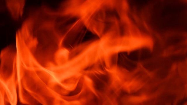 Fire flames with flying sparks background. Firestorm texture, shot of flying fire sparks in the air. Sparks from bonfire backdrop. Slow motion 4K