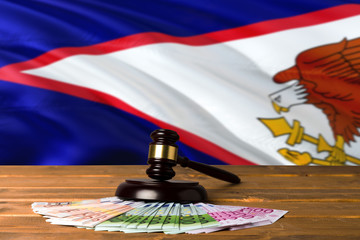 American Samoa bribing concept. Law theme, mallet of the judge on wooden desk with national flag...