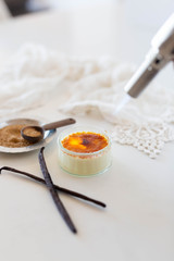 Torching a creme brûlée in white kitchen