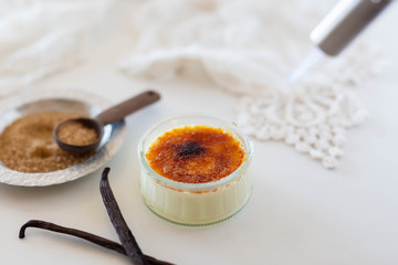 Torching a creme brûlée in white kitchen