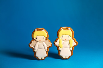 gingerbread cookie of cute little angels on blue background. Traditional Christmas food. Christmas and New Year holiday concept. Copyspace