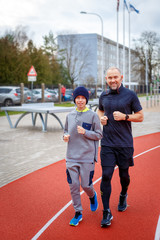 The happy father and a son running on a stadium