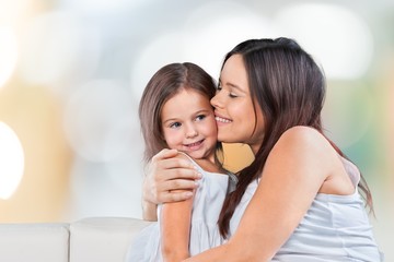Happy Mother and daughter hugging sitting on the sofa