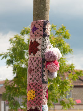 Yarn bombing in Persan, France. Poles, benches and trees are decorated with multicolored knitted and crocheted pieces.