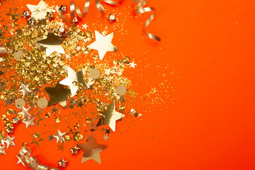 Golden sparkles on coral background. Holiday concept.