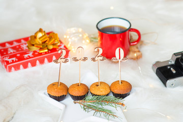 new year and christmas 2020, figures of the new year 2020 on cupcakes, a cup of cocoa, a gift, new year lanterns