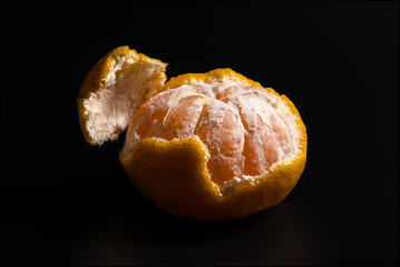 Organic orange yellow mandarin citrus fruit slices, isolated on black background