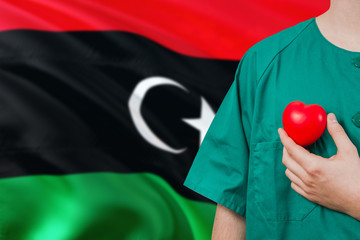 Libya veterinary clinic concept. Veterinarian is holding plastic heart in green uniform on national...