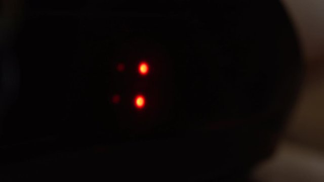 Close-up of black digital clock screen showing 17.00. Blinking red digital numbers on black background. Modern timer system and neon light, electric alarm device