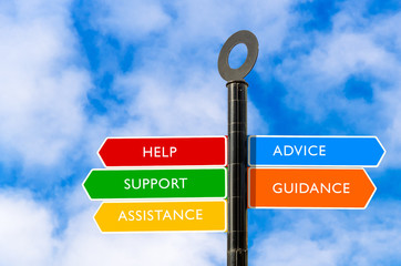 Colourful conceptual directional signs about help and assistance and blue sky in background